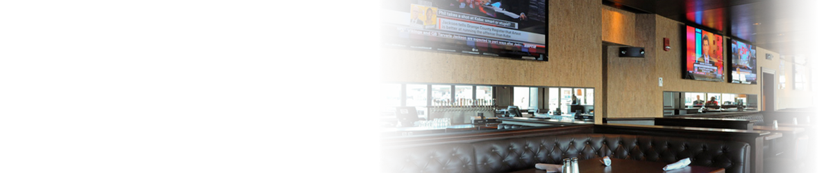 brown leather booths in a restaurant with lots of large hanging tvs